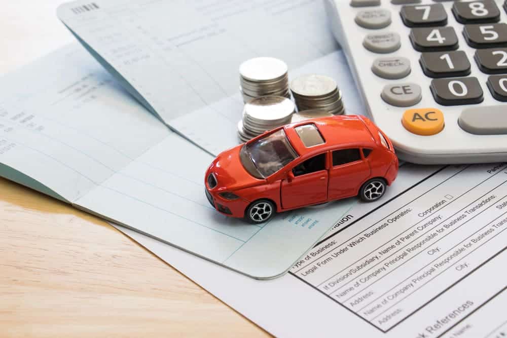 A photo of a Red Toy Car On Top Of Some Documents And Coins, used on the Casares Injury Law website, Castle Rock car and motorcycle accident attorneys