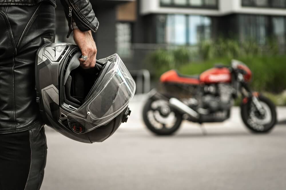 A motorcycle rider with a helmet in the hand, photo used on used on the Casares Injury Law website, Castle Rock car accident lawyers